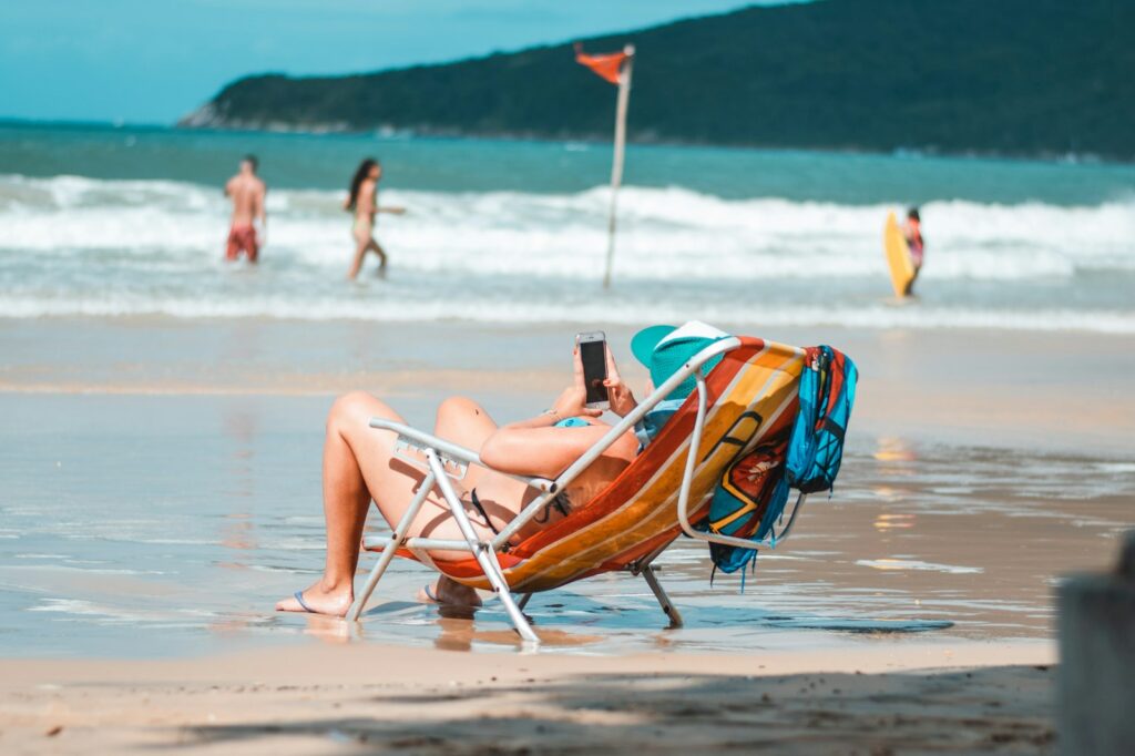 woman lying on orange and yellow sun lounger on beach during daytime